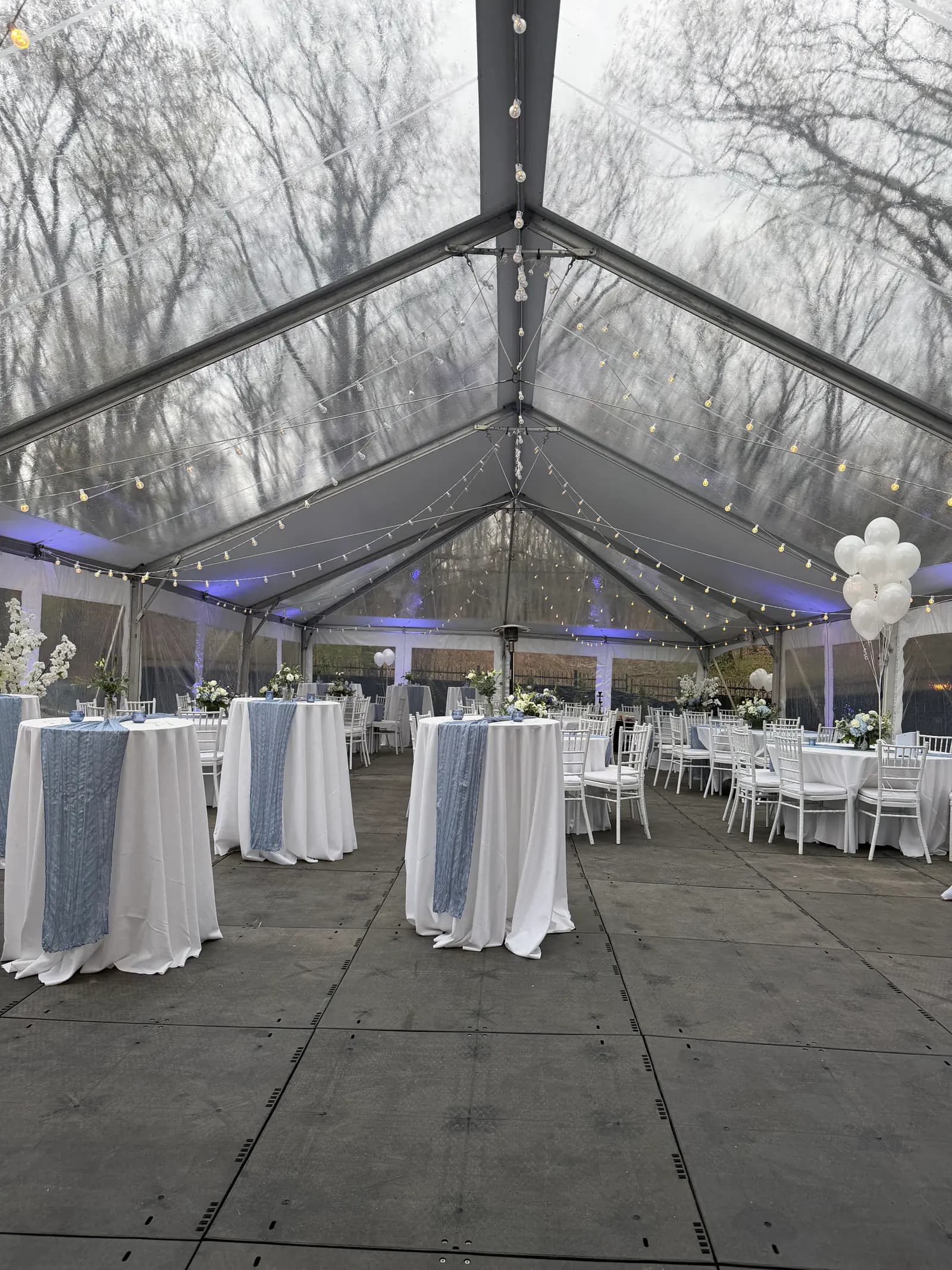Clear-top tent reception with blue linens and fairy lights at a Boston Greek celebration